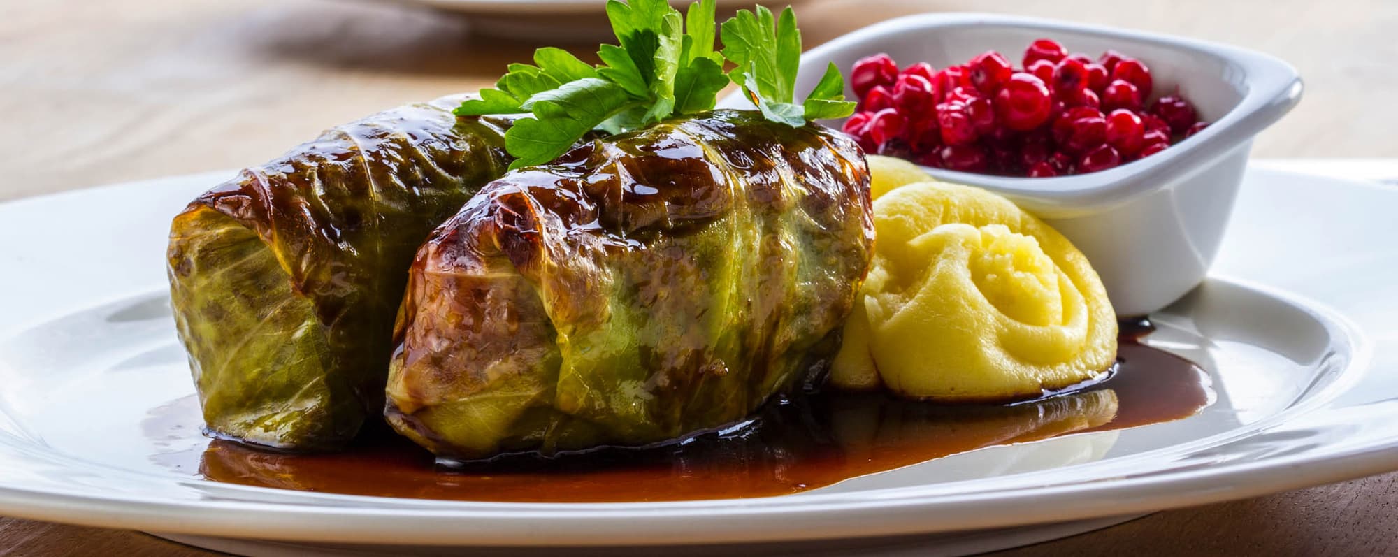 Ett fat med kåldolmar, potatis och lingon