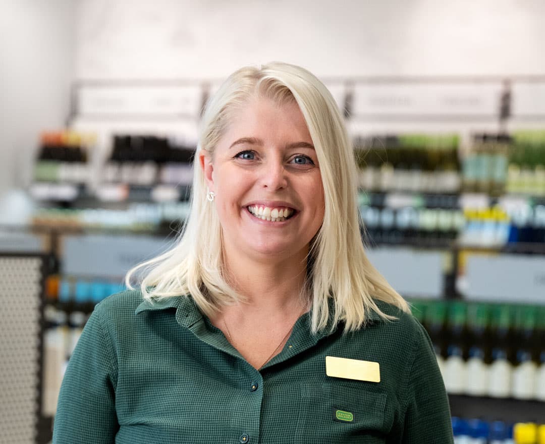 Kvinnlig försäljare i systembolagsbutik
